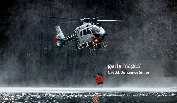 Police helicopter takes water out of the Thumsee lake to fight a mountain forest fire on April 13 near Bad Reichenhall, Germany. Peggy", a high...