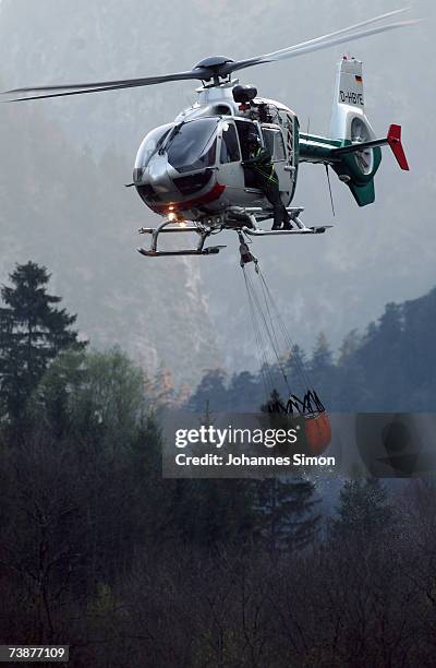 Police helicopter carries water to fight a mountain forest fire on April 13 near Bad Reichenhall, Germany. Peggy", a high pressure system with...