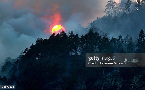 Police helicopter carries water to fight a mountain forest fire on April 13 near Bad Reichenhall, Germany. "Peggy", a high pressure system with...