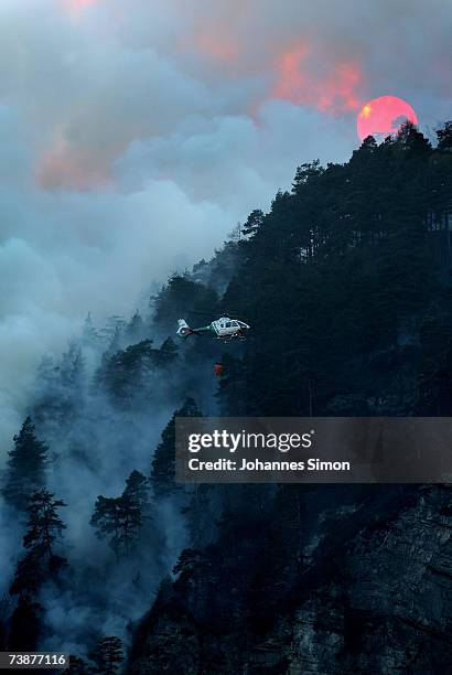 Police helicopter carries water to fight a mountain forest fire on April 13 near Bad Reichenhall, Germany. Peggy", a high pressure system with...