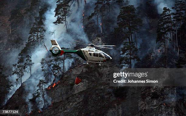 Police helicopter carries water to fight a mountain forest fire on April 13 near Bad Reichenhall, Germany. Peggy", a high pressure system with...