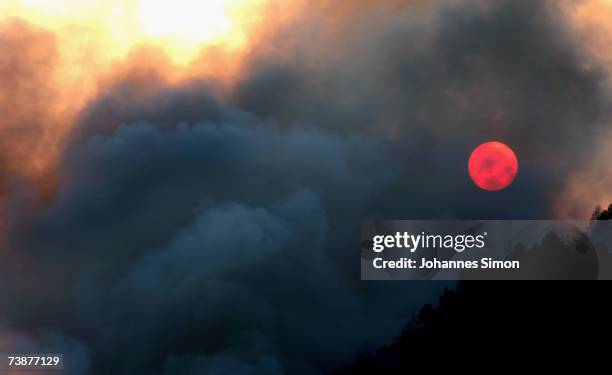The sun is seen through dense fog during a mountain forest fire on April 13 near Bad Reichenhall, Germany. Peggy", a high pressure system with...