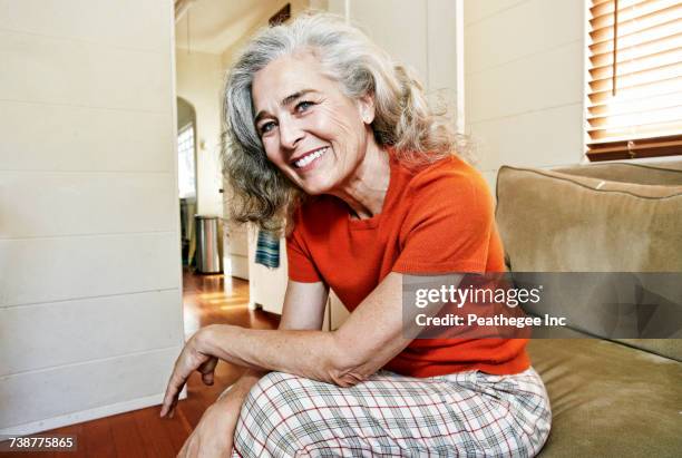 portrait of older caucasian woman sitting on sofa - 60 64 jahre stock-fotos und bilder