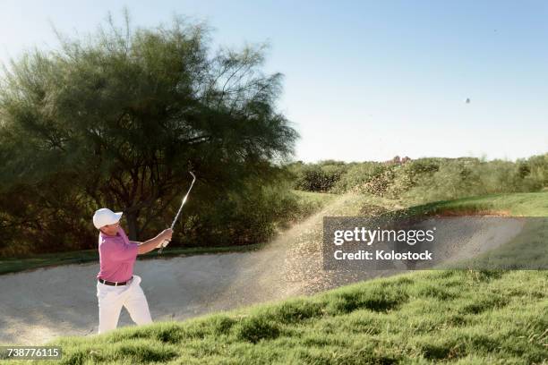 hispanic golfer hitting ball in sand trap - bunker 個照片及圖片檔