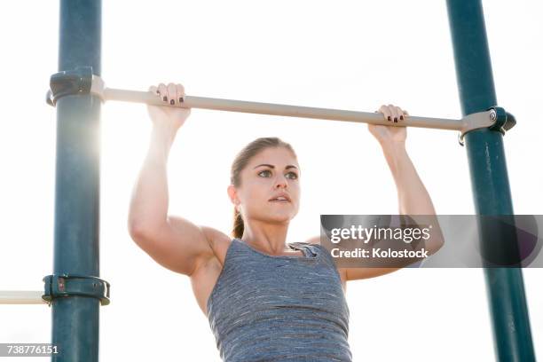 hispanic woman doing chin-up outdoors - chin ups stock pictures, royalty-free photos & images