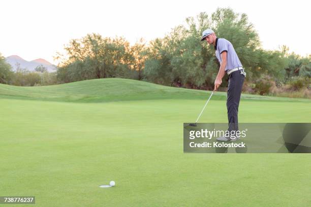 caucasian golfer putting on golf course - golf putting stock pictures, royalty-free photos & images