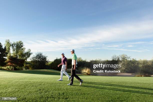 friends walking on golf course - golf player stock pictures, royalty-free photos & images