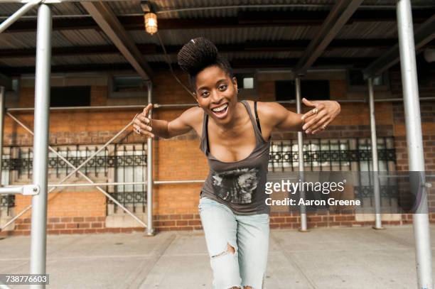 smiling african american woman dancing under scaffolding - einzelne frau über 30 stock-fotos und bilder