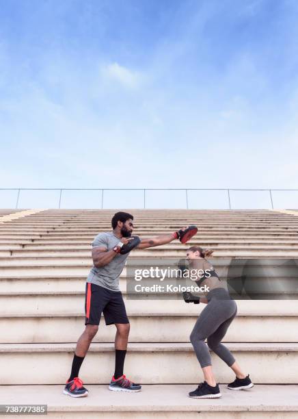 trainer and woman boxing on bleachers - mixed boxing fotografías e imágenes de stock