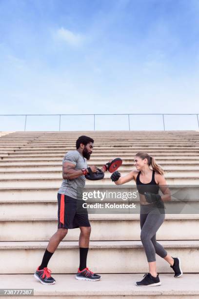 trainer and woman boxing on bleachers - mixed boxing fotografías e imágenes de stock