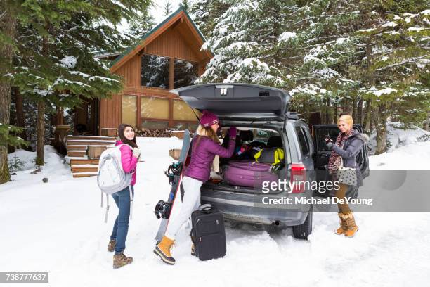 friends unloading car at winter resort - car arrival stock pictures, royalty-free photos & images