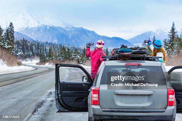caucasian women photographing from car with snowboards - white glove phone stock pictures, royalty-free photos & images