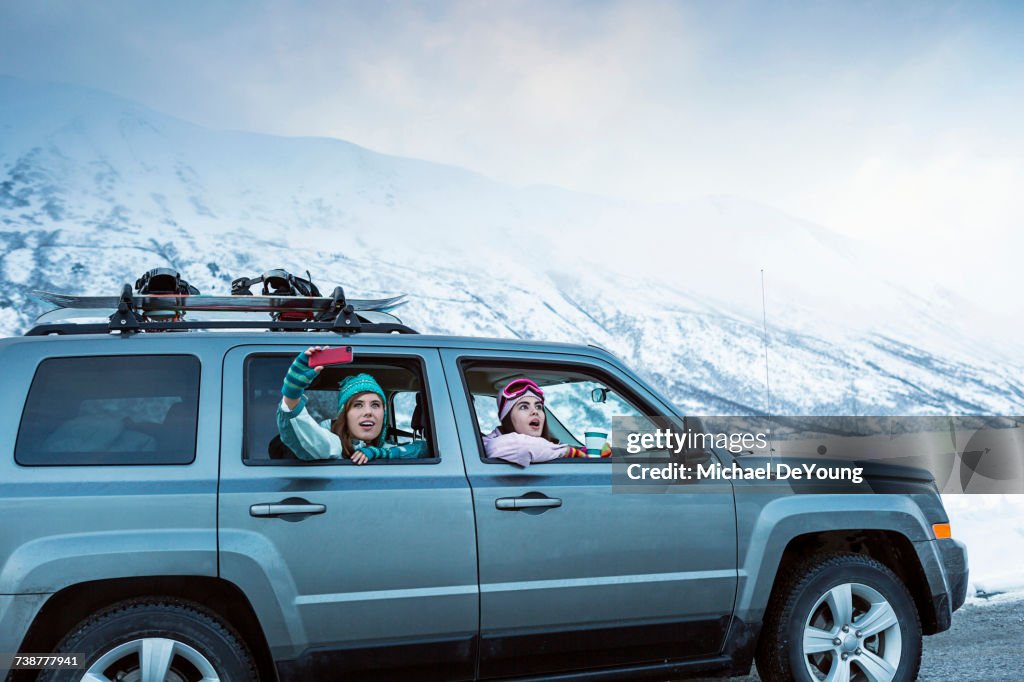 Friends photographing from car in winter
