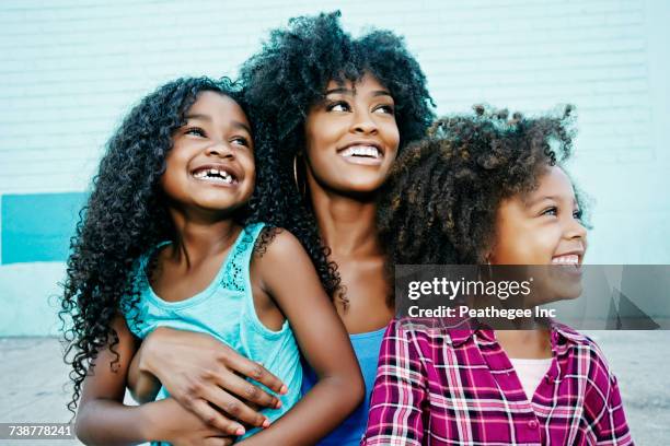 smiling mother and daughters looking away - indian beautiful girls stock-fotos und bilder