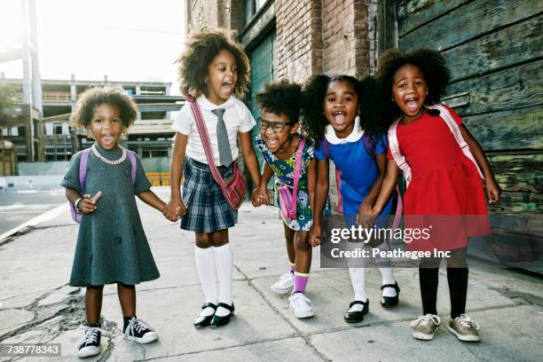 portrait of girls laughing on sidewalk - black skirt stockfoto's en -beelden