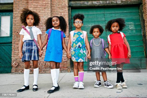 serious girls posing on city sidewalk - sister stockfoto's en -beelden