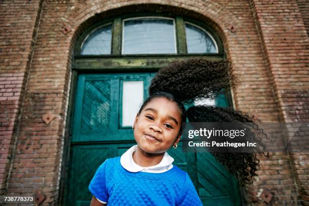 smiling black girl tossing hair - haarzopf stock-fotos und bilder