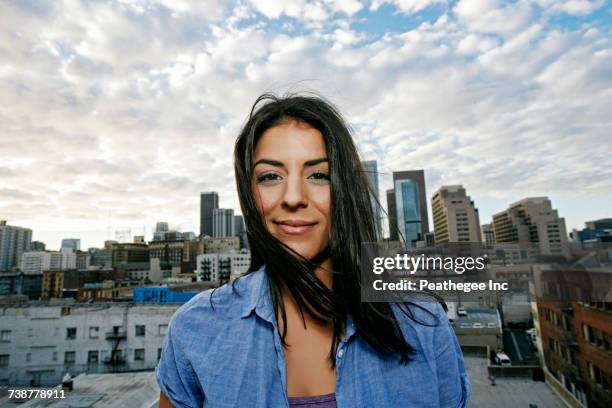 Portrait of smiling Hispanic woman on urban rooftop