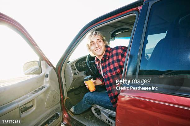 caucasian man sitting in cat holding coffee cup - coffee car design stock pictures, royalty-free photos & images