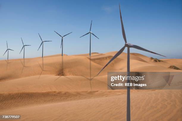 row of wind turbines in desert - sable ondulé photos et images de collection