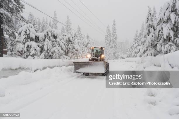 tractor with snow plow driving on remote road - truckee fotografías e imágenes de stock