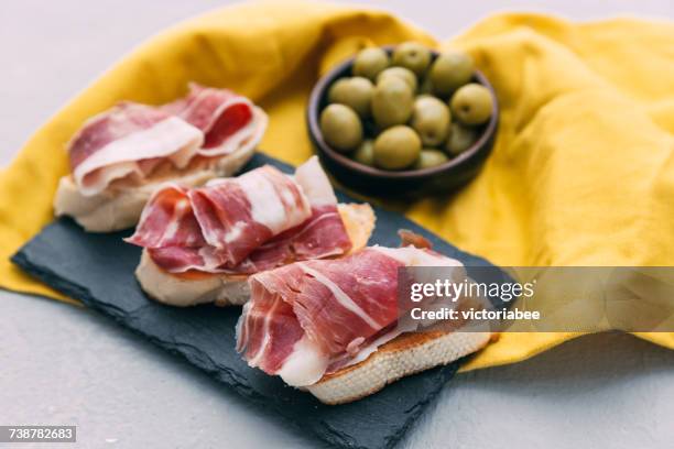 bruschetta with prosciutto and a bowl of olives - jamón serrano fotografías e imágenes de stock