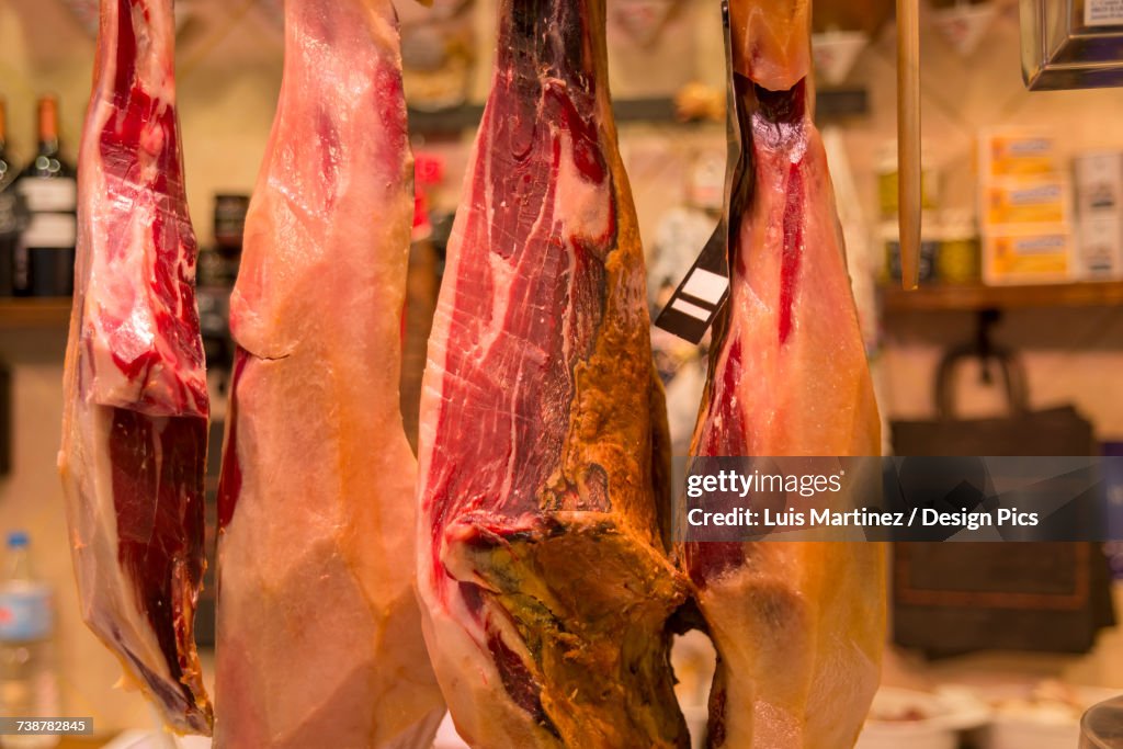 Spanish ham hung in a shop in Boqueria Market, one of the most famous markets around Spain and the most famous in Barcelona