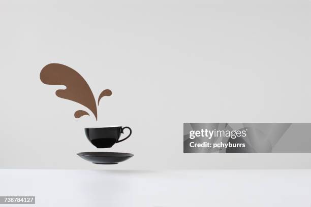 conceptual spilled coffee from floating cup and saucer - pchyburrs stock pictures, royalty-free photos & images