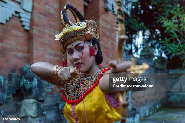 woman holding a bow and arrow in a traditional dance, ubud, bali, indonesia - bali dancing stock pictures, royalty-free photos & images