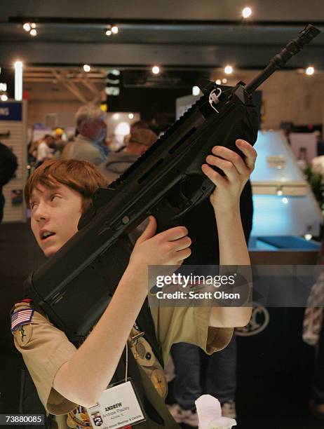 Boy Scout Andrew Pauley looks over a FN rifle during the 136th NRA Annual Meetings and Exhibits April 13, 2007 in St. Louis, Missouri. The four-day...