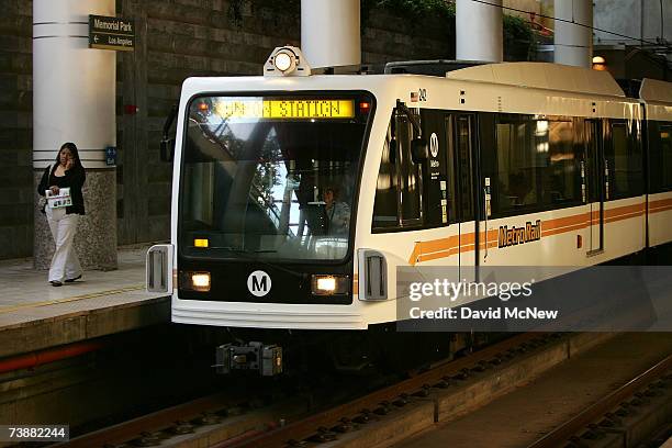 Woman is passed by a Los Angeles-bound Metro Rail train as commuters bypass rush-hour traffic on April 13, 2007 in Pasadena, California. As the...