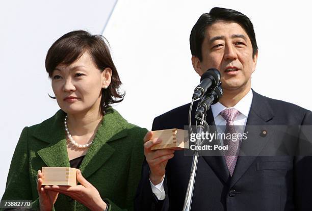 Japanese Prime Minister Shinzo Abe gives a toast accompanied by his wife Akie during his annual cherry blossom viewing party at the Shinjuku Gyoen...