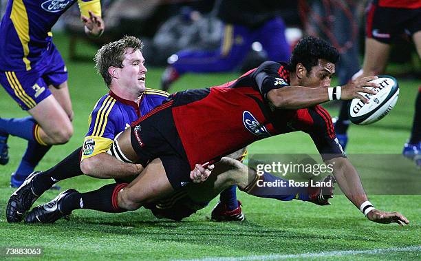 Casey Laulala of the Crusaders reaches out to score a try despite the tackle of Toby Morland of the Highlanders during the round 11 Super 14 match...