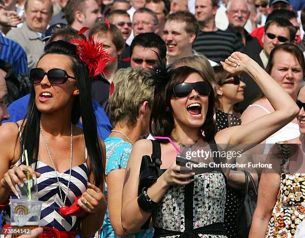 Race goers Sam Lewis, and Lisa Seddon enjoy the warm weather and celebrate a win in the first race of the day on April 14, 2007 in Aintree, England....