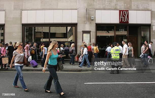 Shoppers queue in a line to enter the Primark store on Oxford Street in London on April 14, 2007 in London.