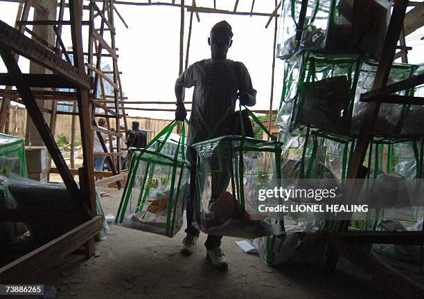 Port Harcourt, NIGERIA: An election official from the Independent National Electoral Commission carries ballot boxes into a voting centre, 14 April...