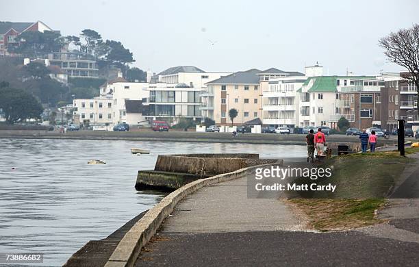 People walk past property overlooking the water in Sandbanks on April 14 2007 in Poole, Dorset. The area has some of the most expensive and exclusive...