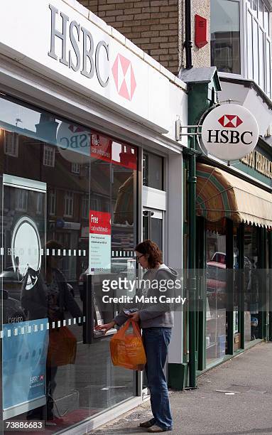 Woman uses a cash machine outside the branch of HSBC in Canford Cliff on April 14 2007 in Poole, Dorset. The area has some of the most expensive and...