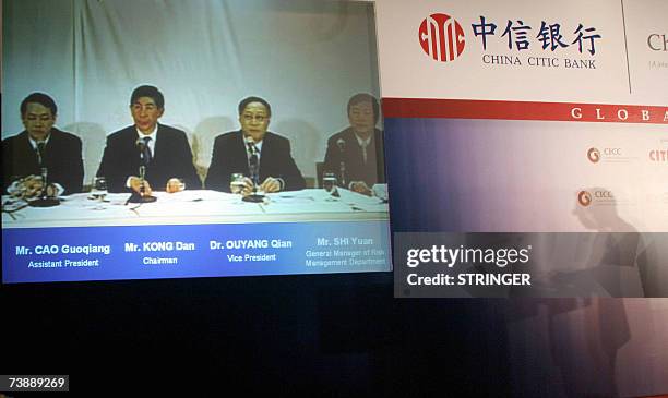 Chairman of China CITIC Bank, Kong Dan , is pictured on a video screen with assistant president Cao Guoqiang , vice president Ouyang Qian and general...