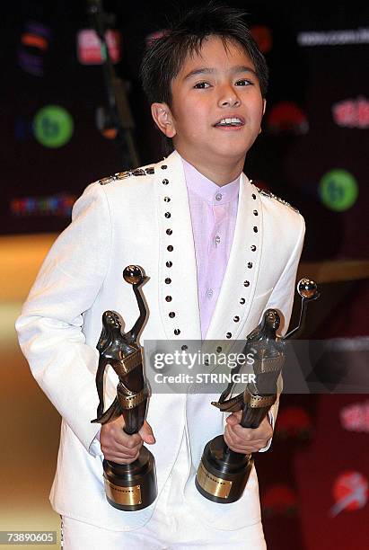 Hong Kong's young actor Gouw Ian Iskandar poses with his trophies after winning the Best New Performer and Best Supporting Actor at the 26th Hong...