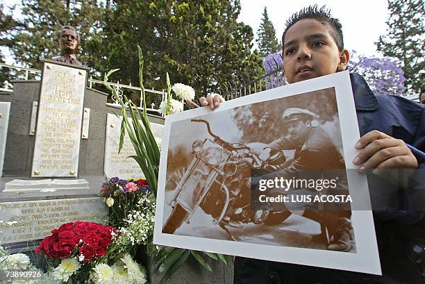 Young fan holds a picture of the late Mexican actor and singer Pedro Infante, in front of his tomb during the commemoration of the 50th anniversary...