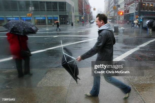 Man walks with his broken umbrella April 15, 2007 at Astor Place in New York City. The East coast is bracing for a severe nor'easter bringing heavy...
