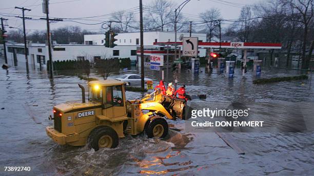Mamaroneck, UNITED STATES: Emergency workers ride through flood waters on the front of a front end loader 15 April, 2007 in Mamaroneck, New York....
