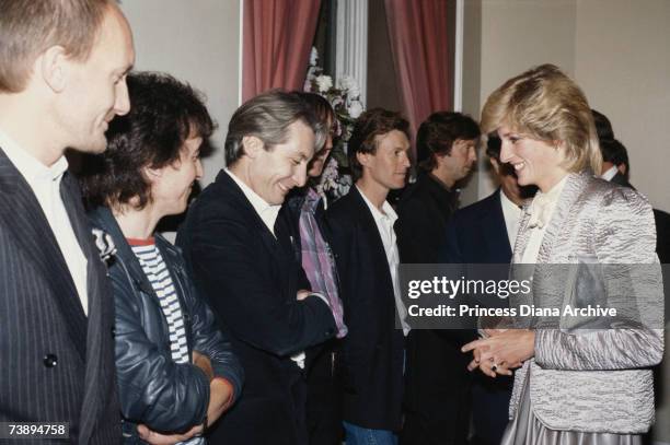 Princess Diana shares a joke with Rolling Stones drummer Charlie Watts after a rock concert at the Albert Hall, London, September 1983. Guitarist...