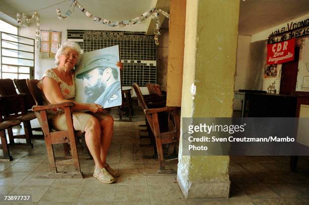 Member Ofelia Lopez holds a Fidel Castro photo April 4, 1999 in Havana, Cuba.