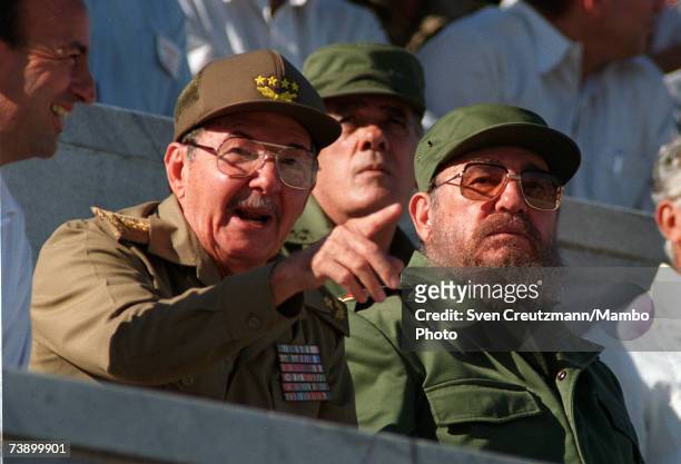 Fidel Castro and his brother Raul attend a parade December 2, 1996 in Havana, Cuba. Carlos Lage is at left.