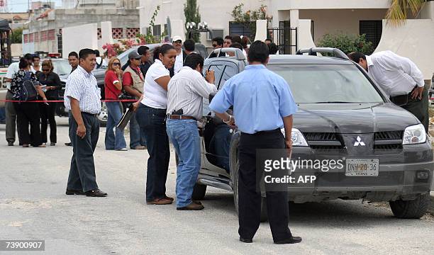 Peritos de la Procuraduria de Justicia del estado de Quintana Roo revisan el 16 de abril de 2007 uno de los cinco cuerpos encontrados en un vehiculo...