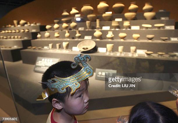 Boy wears a souvenir headband of the flying divine birds, during a visit to the newly opened Jinsha Museum in Chengdu, southwest China's Sichuan...