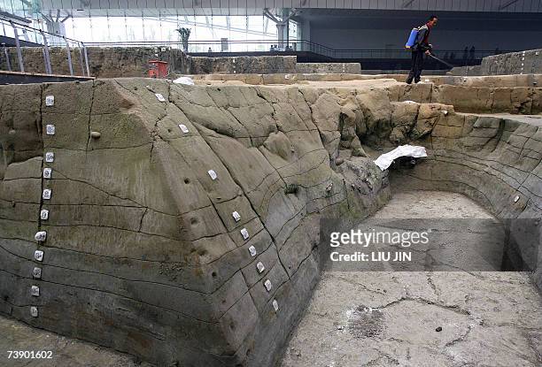 Worker sprays water on the excavation site to keep it damp at the Jinsha Museum in Chengdu, southwest China's Sichuan province 14 April 2007. With an...
