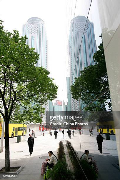 People walk past office buildings on April 16, 2007 in downtown Wuhan of Hubei Province, China. According to data with the National Development and...